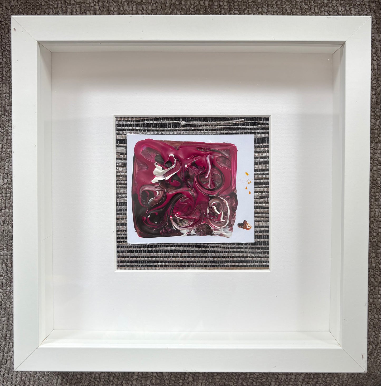 Crimson Tide explores movement, texture and the interplay of colour. Layers of crimson, damson, cream and charcoal fold and flow across the surface, creating a sense of energy held beneath the painting's glossy finish. Mounted on woven grasscloth selected to complement the palette, the work sits at the intersection of art and interiors, where paint, texture and presentation become equally important elements of the finished piece.