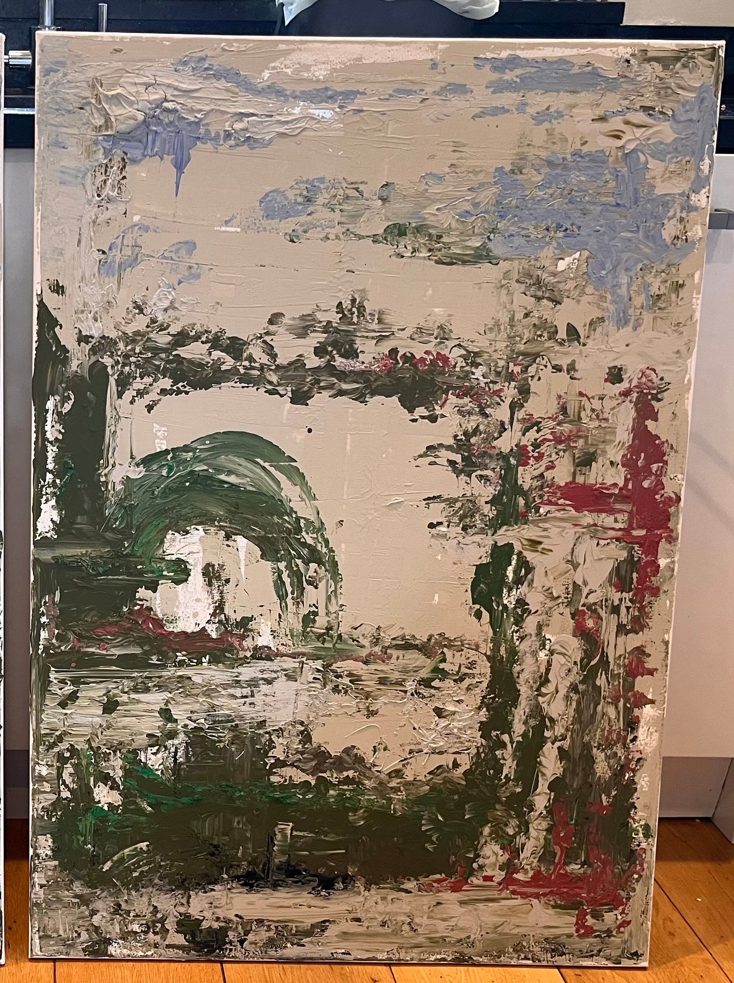 Two abstract paintings side by side on a wooden floor.