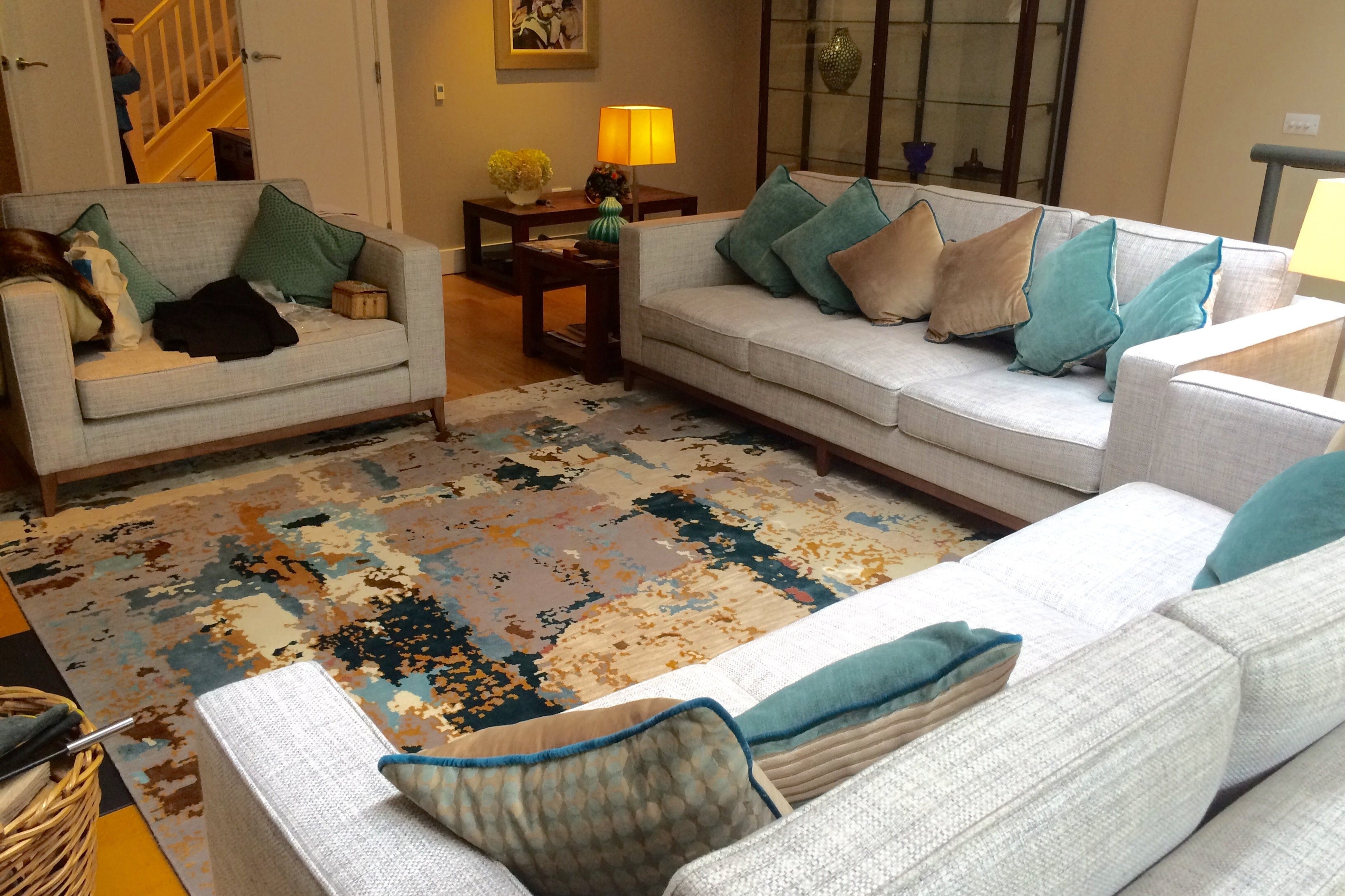 Living room with gray sofas, colorful pillows, and a patterned rug by jennifer manners fleur ward interior design.