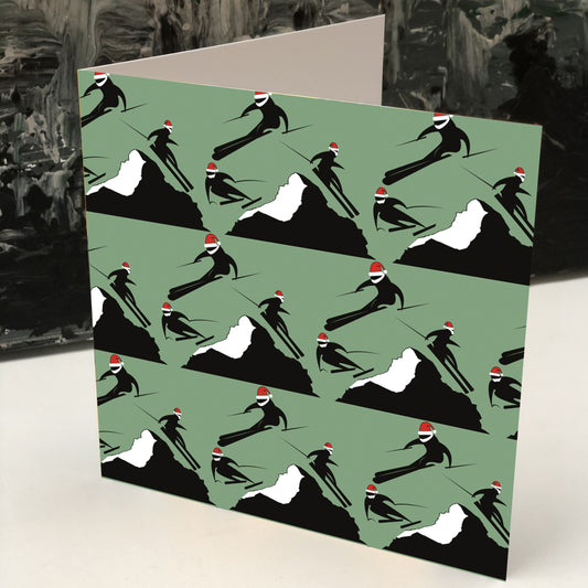Christmas card with rows of 3 skiers on either side of a mountain wearing red santa hats .