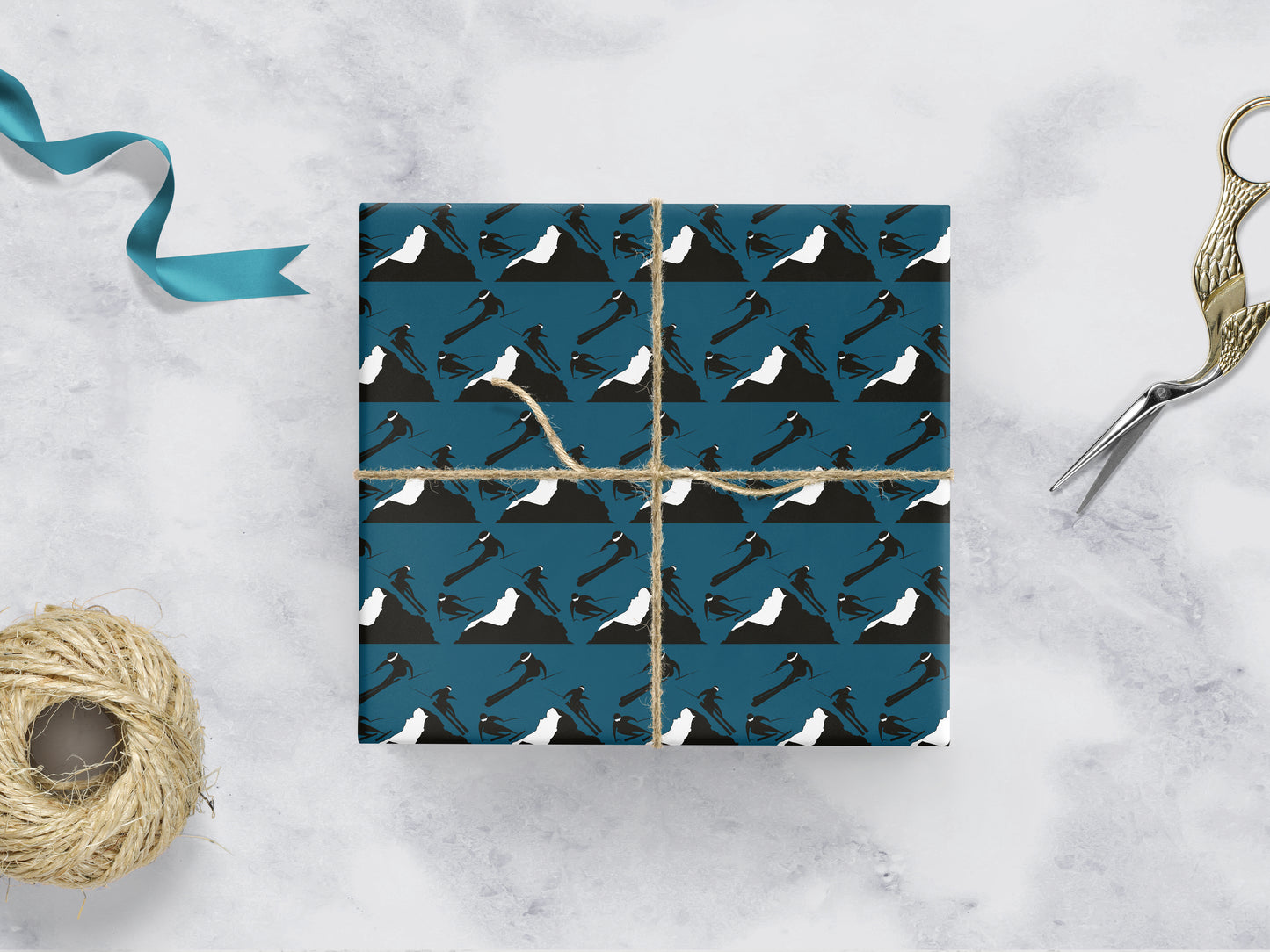 teal gift wrapping with rows of 3 skiers on either side of a mountain